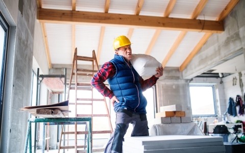 Image of a man lifting an heavy item and hurting his back